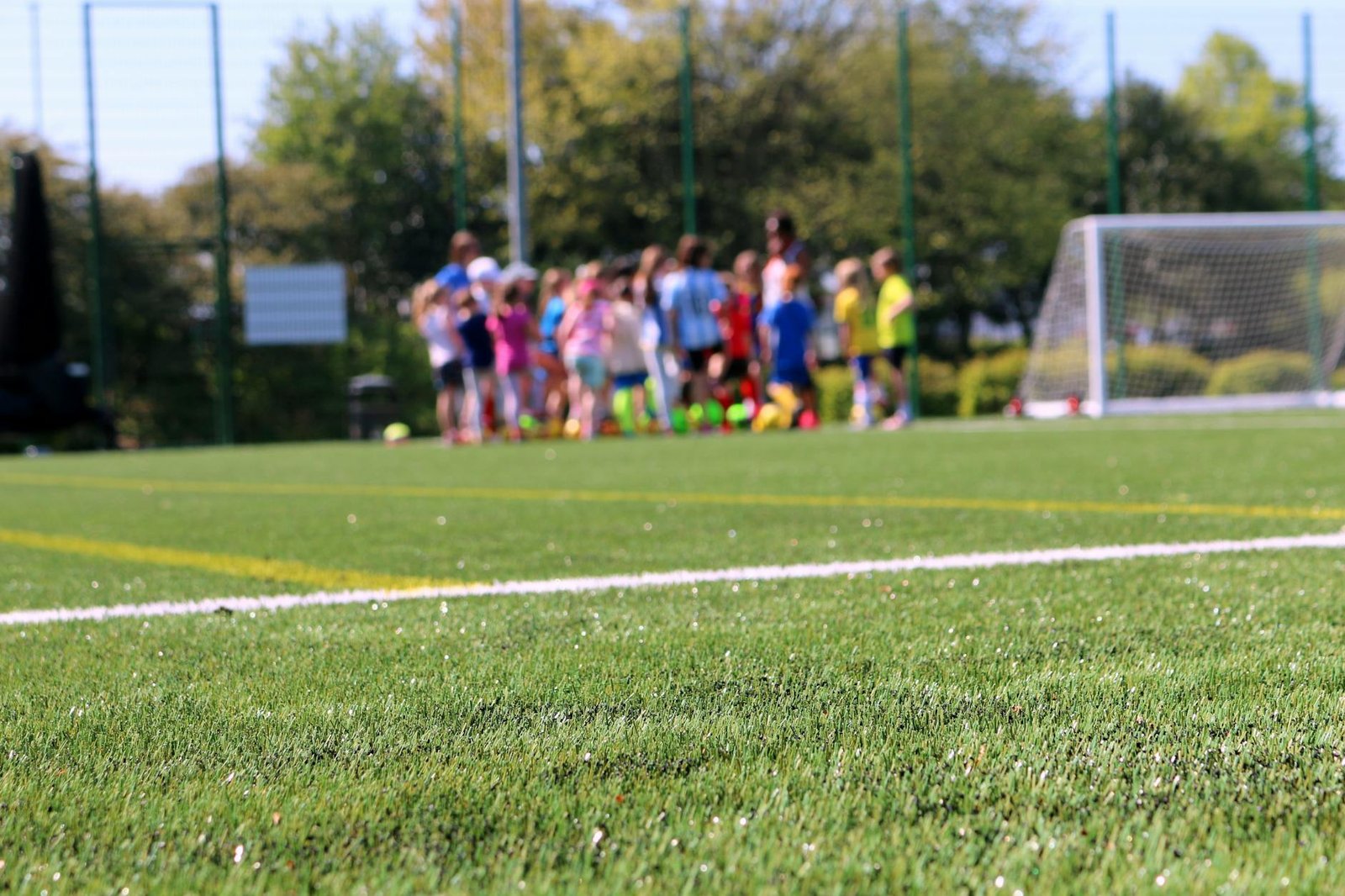 Children practicing soccer on a green field